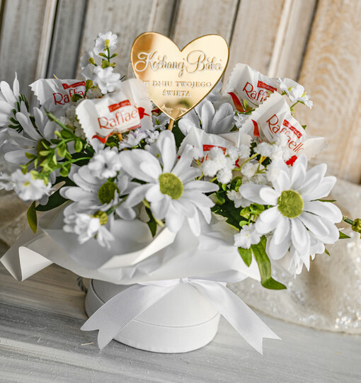 Prezenty dla Babci i Dziadka Prezenty dla Babci Elegancki flowerbox ze sztucznymi kwiatami i słodyczami to wyjątkowy prezent dla babci. Piękna kompozycja w ozdobnym pudełku – gotowy prezent na dzień Babci