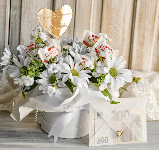  Prezenty dla Młodej Pary  flowerbox, kartki z życzeniami, pudełka na prezenty Elegancki flowerbox ze sztucznymi kwiatami i słodyczami to wyjątkowy prezent dla Młodej Pary. Piękna kompozycja w ozdobnym pudełku tworzy elegancki i gotowy do wręczenia upominek na ślub