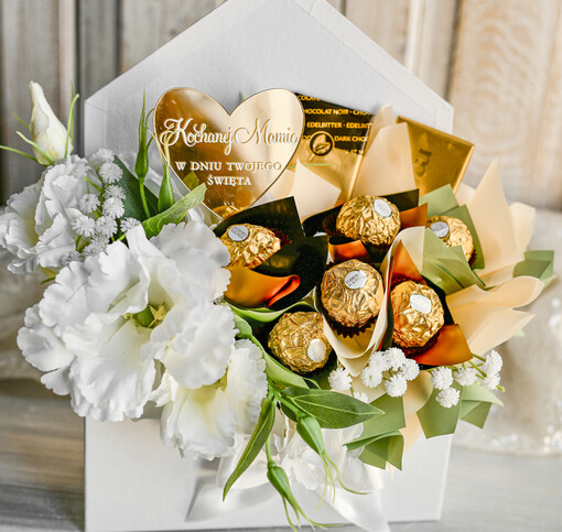 Prezenty dla Mamy flowerboxy, box ze słodyczami  Elegancki flowerbox z sztucznymi kwiatami i słodyczami to wyjątkowy prezent dla mamy. Piękna kompozycja w ozdobnym pudełku – gotowy upominek na każdą okazję. Prezent z okazji dnia mamy