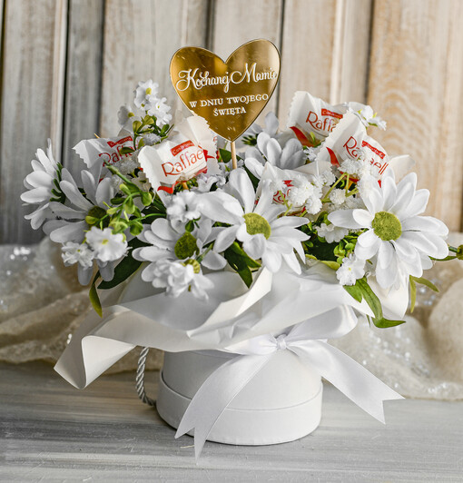  flowerboxy, box ze słodyczami  Elegancki flowerbox z sztucznymi kwiatami i słodyczami to wyjątkowy prezent dla mamy. Piękna kompozycja w ozdobnym pudełku – gotowy upominek na każdą okazję.