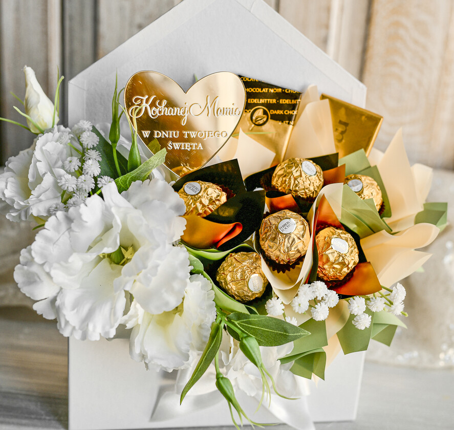 Prezenty dla Mamy flowerboxy, box ze słodyczami  Elegancki flowerbox z sztucznymi kwiatami i słodyczami to wyjątkowy prezent dla mamy. Piękna kompozycja w ozdobnym pudełku – gotowy upominek na każdą okazję. Prezent z okazji dnia mamy0