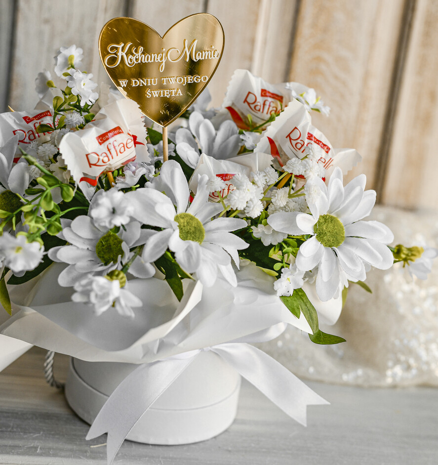 Prezenty dla Mamy flowerboxy, box ze słodyczami  Elegancki flowerbox z sztucznymi kwiatami i słodyczami to wyjątkowy prezent dla mamy. Piękna kompozycja w ozdobnym pudełku – gotowy upominek na każdą okazję.1