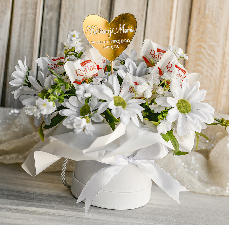 Prezenty dla Mamy flowerboxy, box ze słodyczami  Elegancki flowerbox z sztucznymi kwiatami i słodyczami to wyjątkowy prezent dla mamy. Piękna kompozycja w ozdobnym pudełku – gotowy upominek na każdą okazję.4